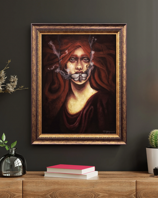 Framed artwork of a woman with red hair and smoldering moths over her mouth on a dark wall with books and plants below.